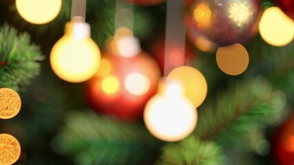 Poster - colorful christmas lights hanging on pine tree with bokeh effect creating a warm holiday ambiance 4k