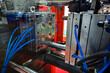 © dizfoto1973 - Close-up view of a shiny metal injection molding tool or die with blue hoses, part of an industrial manufacturing machine used for plastic production.