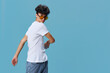 © SHOTPRIME STUDIO - Young man wearing white t-shirt and yellow sunglasses poses confidently against blue background, showcasing casual style and relaxed attitude with natural lighting.