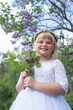 © Karniewska - Smiling Girl in First Communion Dress with Lilac Blossoms
