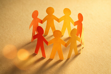 Poster - Collaboration and are symbolized by six interconnected paper figures casting long shadows on a textured surface reflecting teamwork and connection in business environments