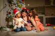 © ultramansk - Three children enjoy Christmas Eve under a beautifully decorated tree, opening gifts with joy and curiosity. A cozy holiday atmosphere filled with love, tradition, and magic.