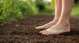 Barefoot person standing on soil in a natural garden setting  