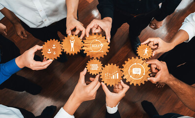 Poster - This image showcases a diverse group of hands holding gears with icons, representing teamwork and collaboration in business strategies and agile project management efforts. Amity