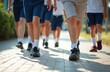 © miss irine - Low section of students walking together on footpath. Boys, girls wearing uniforms, walking toward school. Group of kids in shorts and sneakers. Education, back to school concept.