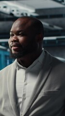 Poster - Vertical video Smiling employee walking in high tech data center with machines powering networks, running companies databases. Admin overseeing server farm with rigs modules processing large datasets