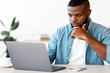 © Prostock-studio - Focused African American Businessman Working With Laptop At Office, Sitting At Desk And Looking At Computer Screen, Black Entrepreneur Thinking About Project Strategy And Business Plan, Copy Space
