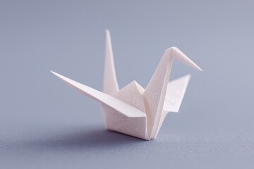 Poster - minimalistic image of single origami crane placed against plain monochrome backdrop with ample copy space