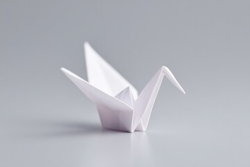 Poster - minimalistic image of single origami crane placed against plain monochrome backdrop with ample copy space