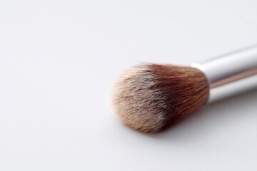 Poster - close-up of single makeup brush resting on plain white background