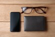 © Chandlerlikes - Flat lay of business accessories including glasses, smartphone, wallet, and watch on wooden desk