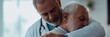 © Aliakbar - Elderly doctor hugging patient in a clinic, a comforting and caring scene of a senior male medical professional with his elderly male patient.
