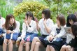 © Masakazu Tokashiki - In early summer in Shanghai, near The Bund, Japanese high school girls in uniforms sit at a street corner, chatting and laughing, their smiles adding a touch of youth to the vibrant city atmosphere.