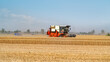 © zhouyilu - Wheat Harvester in Golden Field