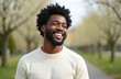© Vadym - Young African American man smiles in park. Happy, confident guy with afro hairstyle, beard enjoying warm weather. Smiling with perfect white teeth in the sunlight, outdoor lifestyle.