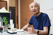 © Masakazu Tokashiki - In a small Japanese apartment, a Japanese man in his late 70s relaxes in T-shirt pajamas. He sits alone in the evening, sipping whiskey and enjoying a calm, quiet moment after a long day of solitude.