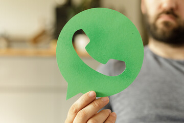 Poster - Close-up of a hand holding a green WhatsApp phone icon.  Perfect for communication, social media, or technology concepts.