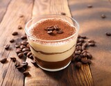 creamy coffee dessert in a glass with chocolate layer and coffee beans scattered around