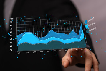 Poster - Stock photo of a businessman interacting with a holographic financial graph showing growth and progress.