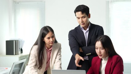 Poster - Professional Asian business team collaborating and sharing strategic insights while examining work details together using laptop in modern bright office environment