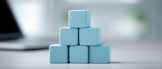 Poster - Blue cubes stacked in pyramid shape on blurred background, creating minimalist and modern aesthetic