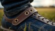 © Mishkat Uddin Rahat - Closeup of denim shoe with leather strap and brass eyelets