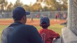 © Cingrid - Father and son watching youth baseball game from bleachers family time at sporting event together outdoor activity