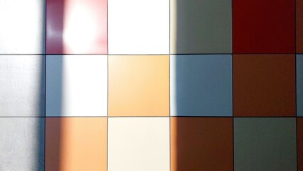 Poster - Colorful Tiled Floor With Shadows Creating Patterns in a Well-Lit Indoor Space During the Day