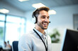 © Crowded Studio - Hombre sonriente con auriculares y micrófono trabaja en una oficina moderna frente a una computadora.Representación visual de la atención al cliente profesional, la comunicación eficaz y la atención