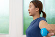 © Kran - Woman exercising with blue dumbbell indoors