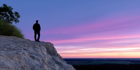 Poster - Man Standing on Cliffside Overlooking Landscape at Sunset, Representing Serenity and Exploration