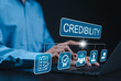 © Supatman - Credibility and trust in business concept. Businessman using laptop with icons credibility, trust, reputation, verification, integrity, reliable, authentic, commitment, regard, and quality assurance.