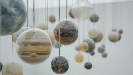Fototapete - Art installation showcasing planets hanging from the ceiling in a bright, modern gallery space