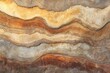 © nikini - Layered rock formation displaying various earth tones, textures, and irregular shapes creating a visually intriguing geological composition.