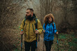 © Zamrznuti tonovi - Hikers walking in forest using trekking poles and backpacks