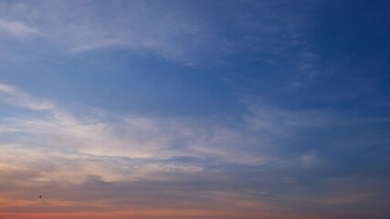 Wall Mural - A beautiful sunrise timelapse capturing soft orange and blue hues blending in the sky. Wispy clouds gently move, bringing warmth and calmness as a new day unfolds with peaceful light. Time lapse.
