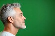 © R - Idea of style for aging men. Green solid background. A chic and vibrant male with effortless elegance. Fashionable men's mullet haircut - midlife arabian man with short hair.