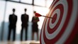 © QuietWord - dart stack on bullseye target  with group of businessman and woman standing together