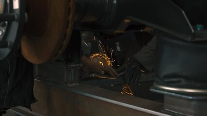 Poster - Worker shapes agricultural semi-trailer parts with pneumatic tools