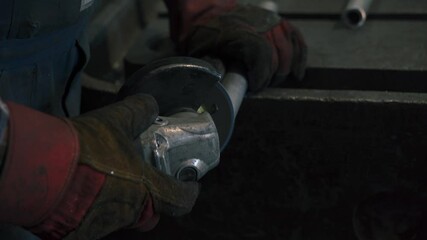 Poster - Worker skillfully grinds metal part with pneumatic tool in workshop setting