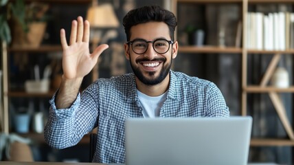 Poster - Engaging young man waves hello while working on laptop in modern workspace
