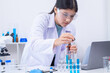 © Rakchanok - Teen scientist girl conducting science test by carefully evaluating blue solution in laboratory. Science, laboratory, experiment, and research demonstrate academic progress and practical skills.