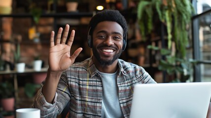 Poster - Person waves hello while using a laptop in a cozy, plant-filled workspace during the day