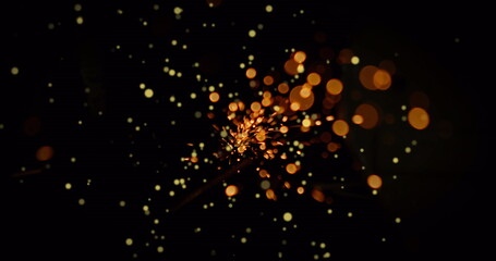 Poster - Flickering sparks glowing brightly in dark field, with ember-like light particles
