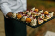 © La Famiglia - Waiter carrying tray of gourmet appetizers at a celebration event