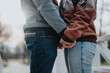 © qunica.com - Two people are standing closely on a bridge holding hands, featuring casual attire and an intimate connection, with a blurred outdoor background creating a serene atmosphere.