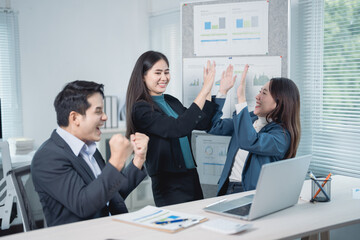 Aufkleber - Asian business team celebrating success in an office meeting, excited entrepreneurs giving high fives after signing a profitable contract, showcasing teamwork and collaboration
