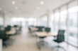 © Tromistudio  - A blurred view of an office space with desks chairs and large windows letting in soft natural light inside
