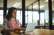 © Wavebreak Media - Female office professional typing on laptop and tablet at desk in open-plan office, copy space