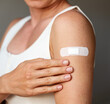 © Barillo Images - Closeup white adhesive bandage on female's shoulder after vaccine shot